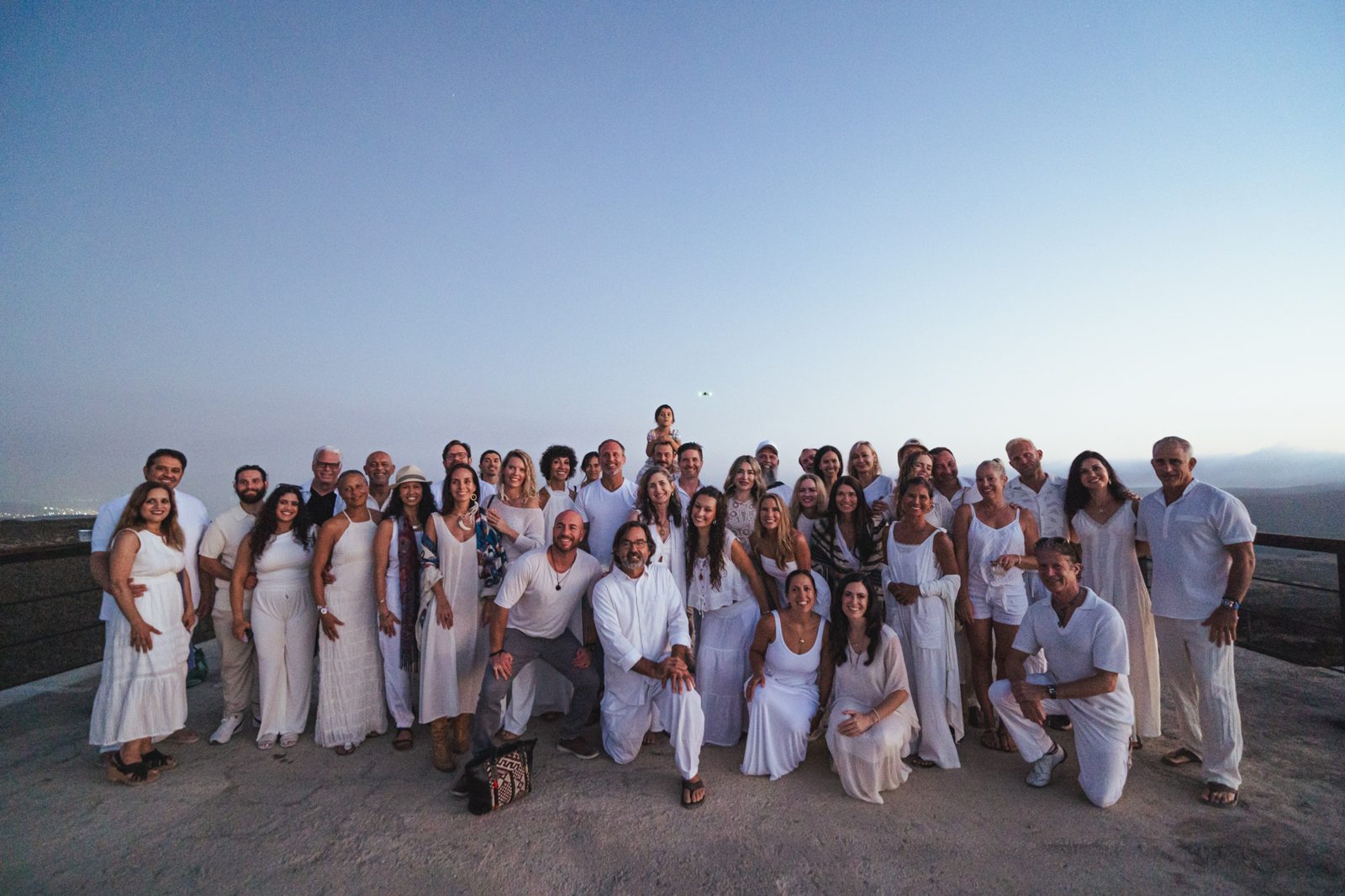 Ethos Baja community gathered in white at sunset