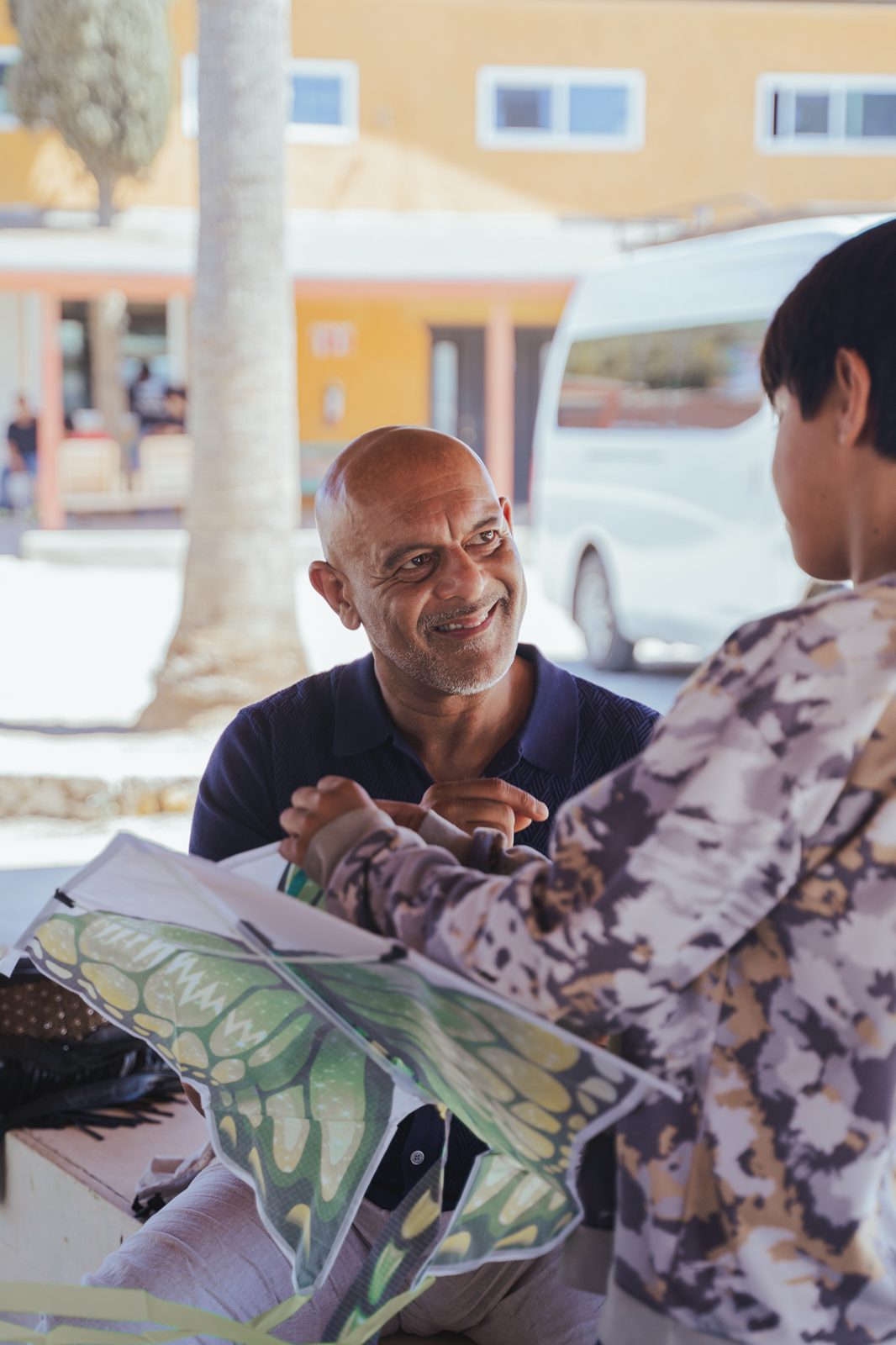 Smiling volunteer building a kite with a child